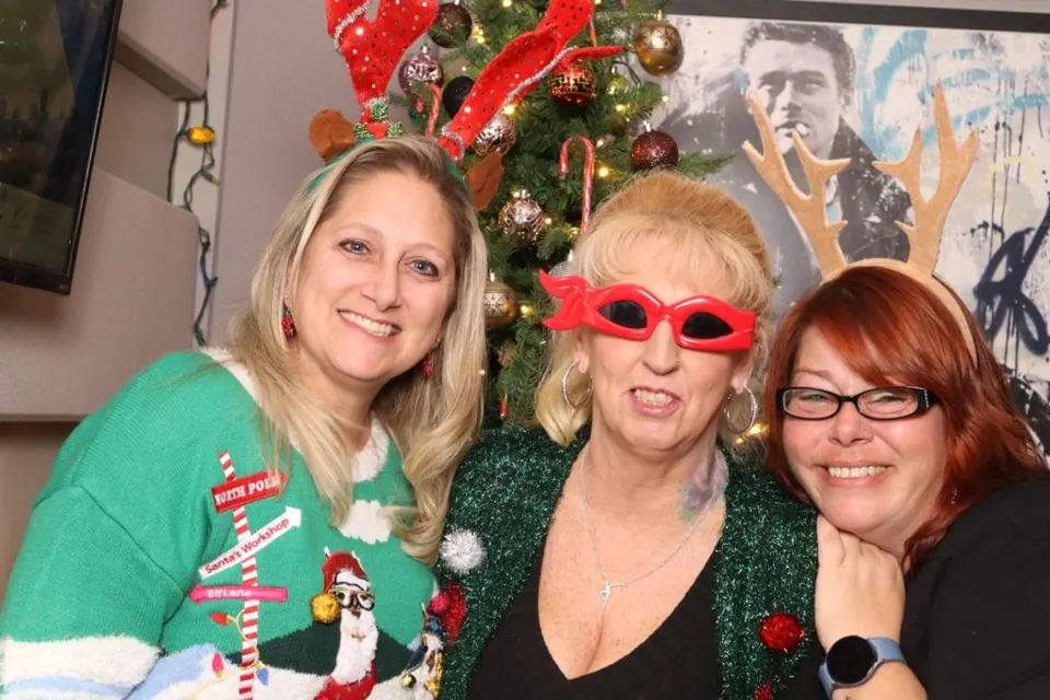 Friends wearing antlers and festive glasses at a past bar crawl