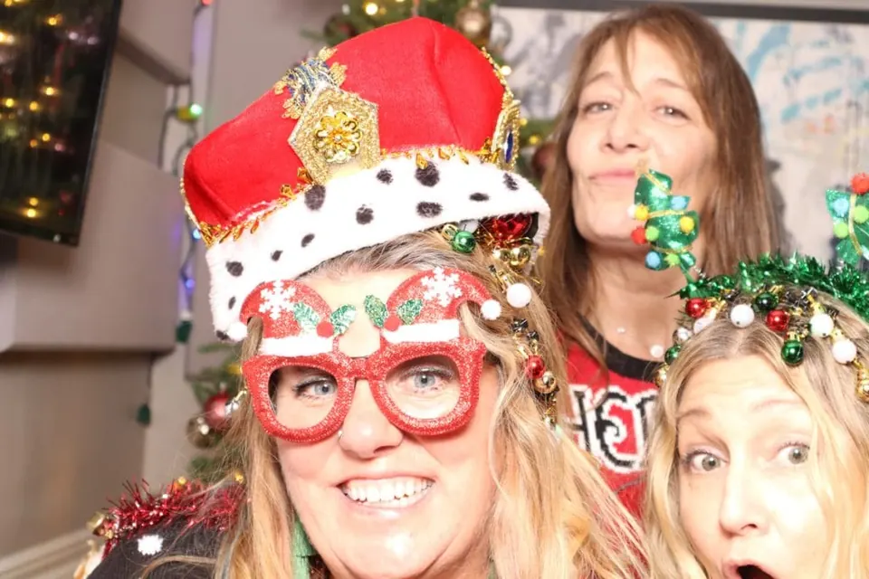 Friends in elaborate holiday hats and glasses